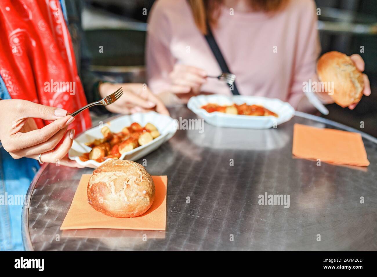 Femme mangeant Currywurst avec du pain dans le café de la rue de Berlin. Concept de cuisine locale allemande Banque D'Images