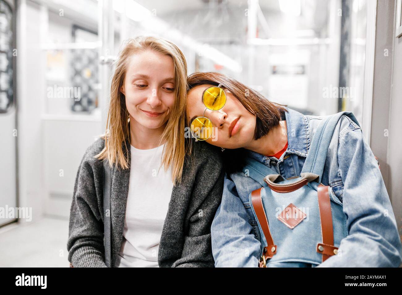 Jeune femme dormant sur l'épaule de sa fille amie dans le métro, l'amitié et le concept sans sommeil Banque D'Images