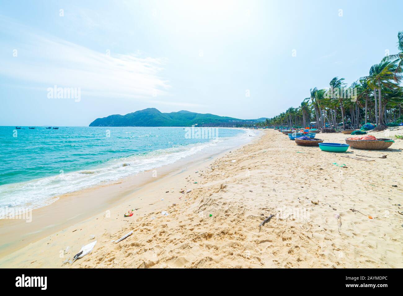 Magnifique plage tropicale turquoise transparent palmiers à eau, Tu Nham bateau de pêche et village, Quy Nhon Vietnam côte centrale voyage destination, d Banque D'Images