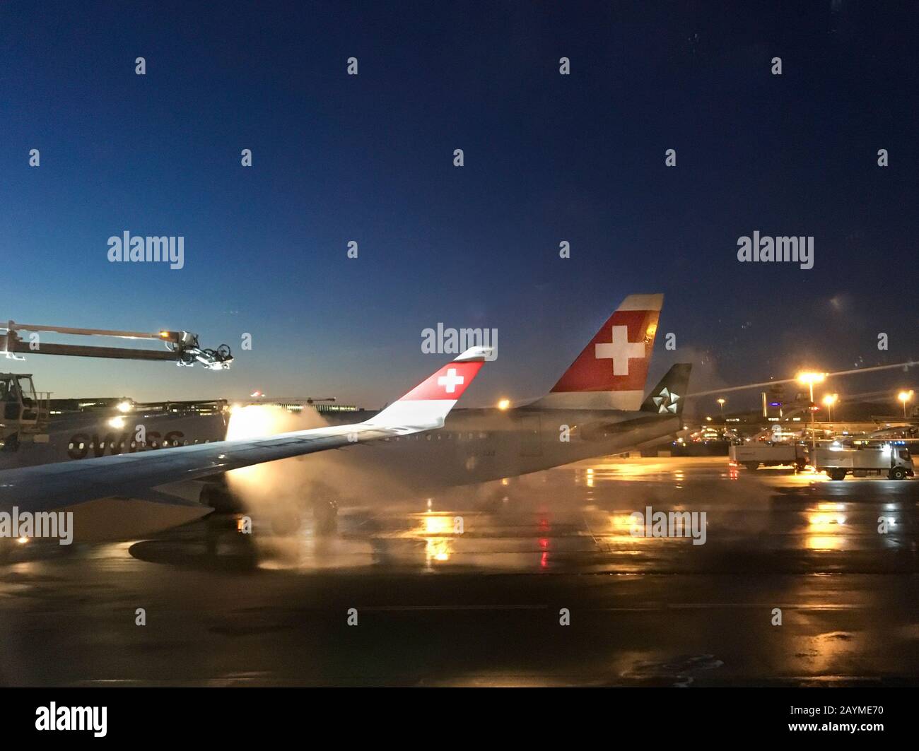 Aéroport de Zurich, Suisse - 15 janvier 2020: Pendant une matinée d'hiver froide, les véhicules spéciaux sont des avions de passagers de dégivrage de Swiss International Airlines à l'aéroport de Zurich Kloten. Pendant les mois d'hiver, la procédure de dégivrage entraîne régulièrement des retards dans le transport aérien. Banque D'Images