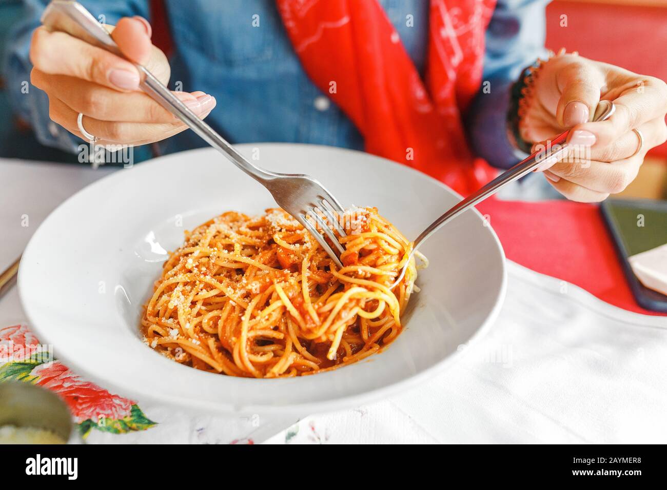 Une jeune femme mange des pâtes italiennes traditionnelles dans le restaurant local Banque D'Images