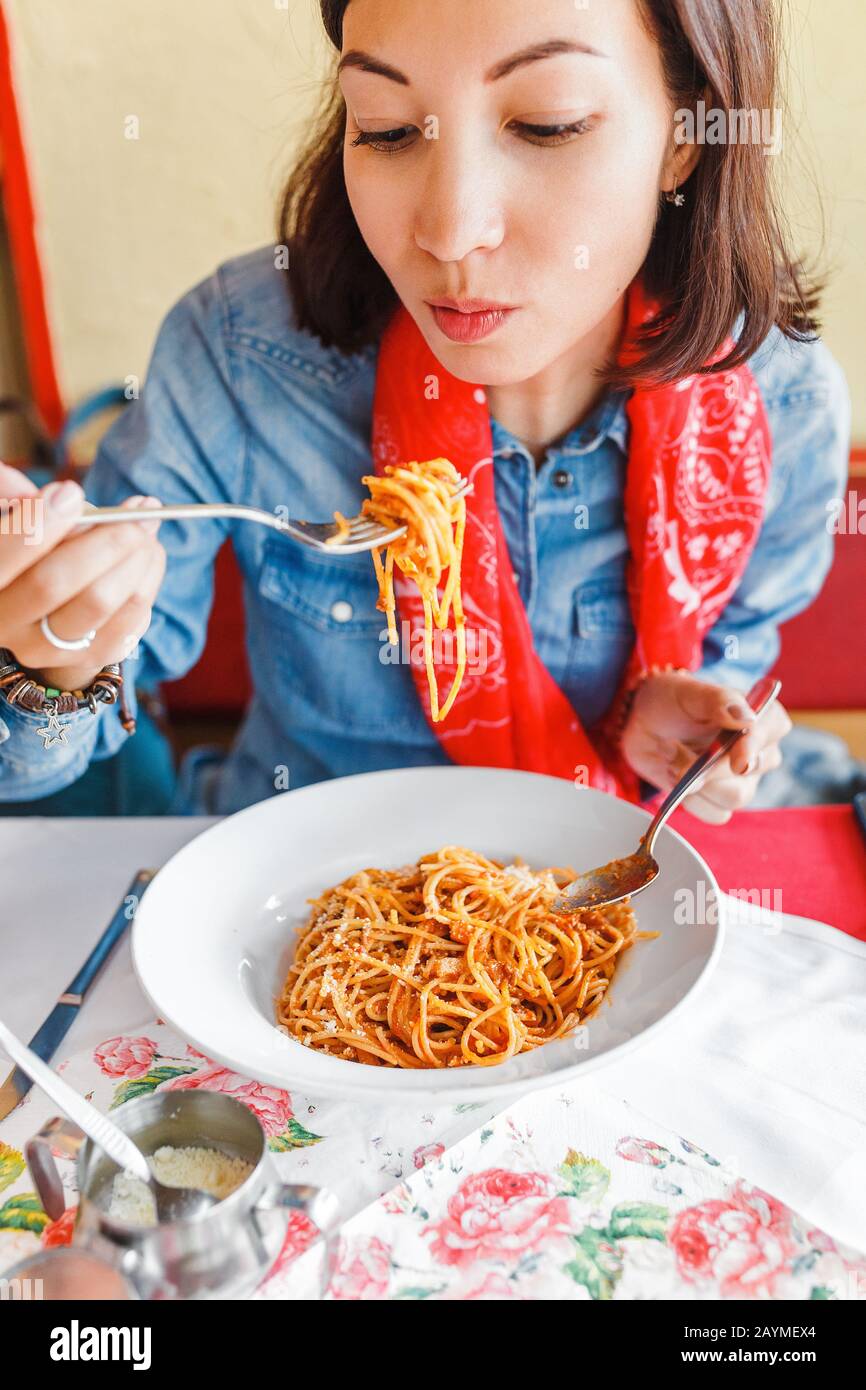 Une jeune femme mange des pâtes italiennes traditionnelles dans le restaurant local Banque D'Images