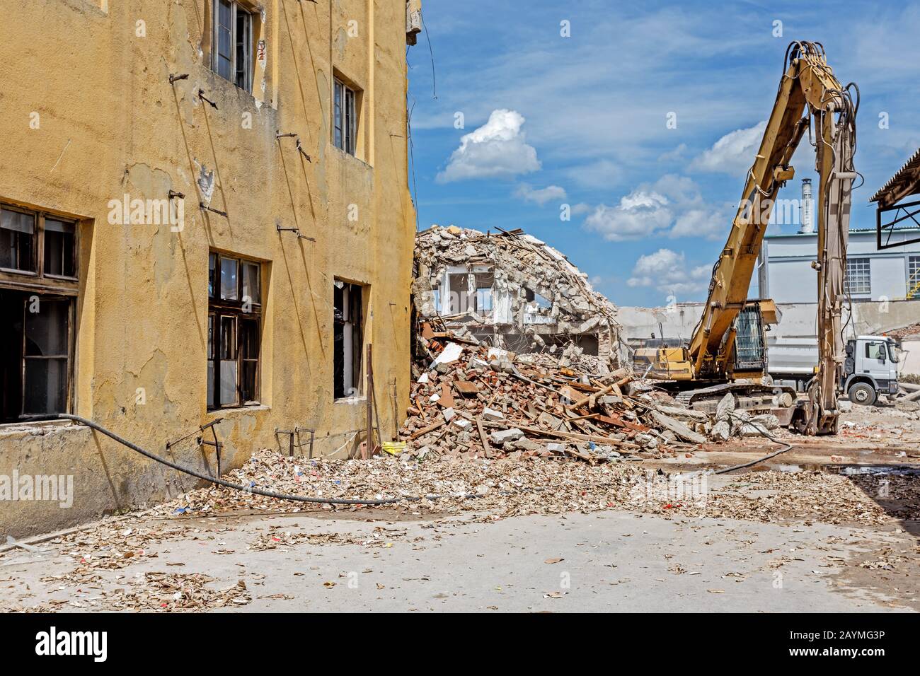 Ruines d'un bâtiment démoli. Machinerie lourde entourée de ruines. Concept de l'industrie de la construction. Banque D'Images