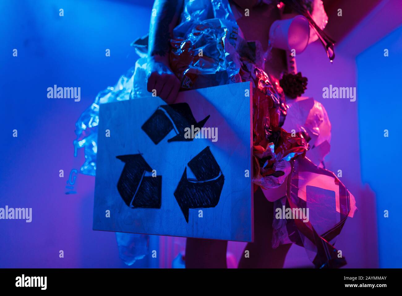 PANNEAU de recyclage : portrait d'une femme souillée écofighter portant une robe à ordures en plastique et en carton pour favoriser la propagation de la nature de nettoyage de l'environnement Banque D'Images