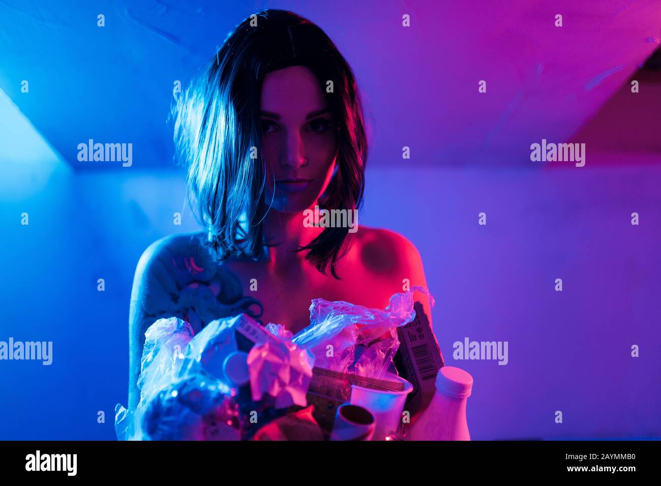 SAC en plastique sur la tête: Sufficaterd Portrait de femme souriante écofighter portant une robe poubelle en plastique et carton pour aider à la propagation de l'environnement Banque D'Images