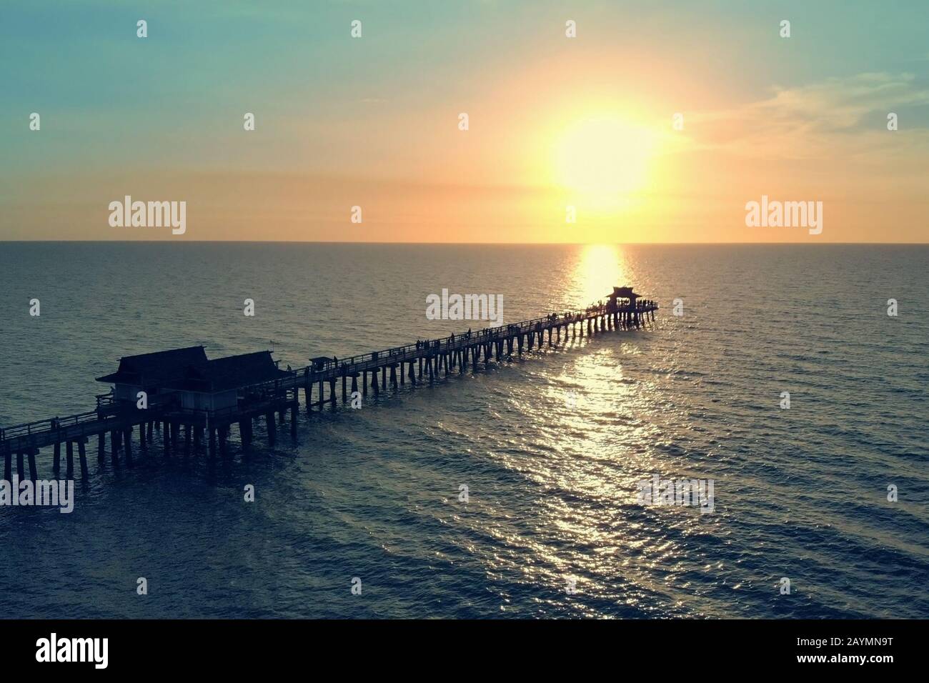 Silhouette d'un quai au-dessus de l'eau au coucher du soleil. Banque D'Images