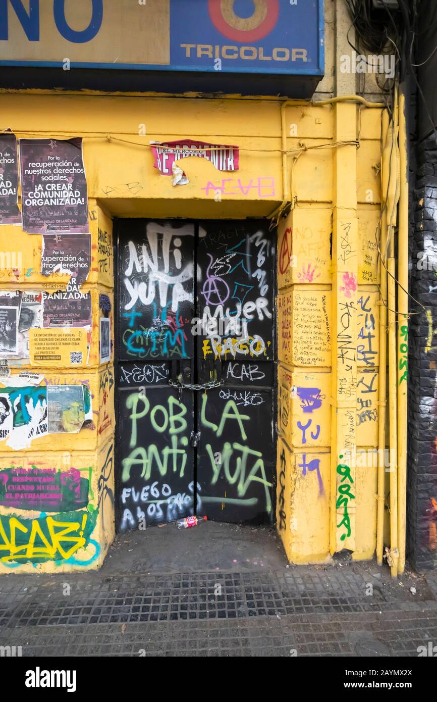 Graffiti et affiches des troubles politiques et des protestations sur un magasin fermé à Lastarria, dans le centre de Santiago, dans la région métropolitaine, capitale du Chili Banque D'Images