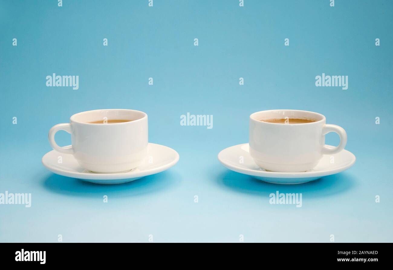 Deux tasses de café blanc avec lait, fond bleu clair, vue latérale. Americano. Espace de copie Banque D'Images