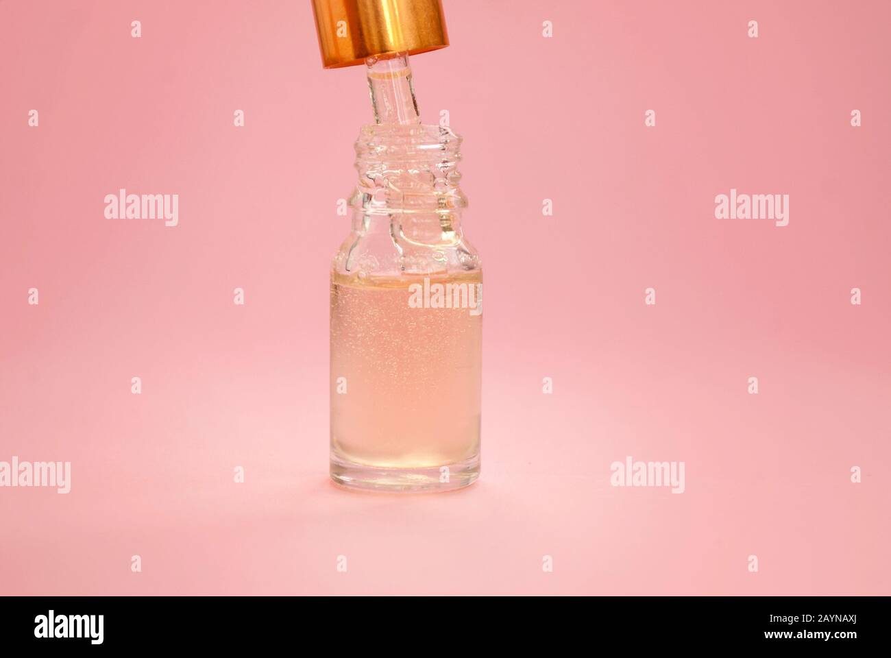 Bouteille d'huile cosmétique, produits sériques de soin de la peau sur un fond rose. Placer pour le texte Banque D'Images