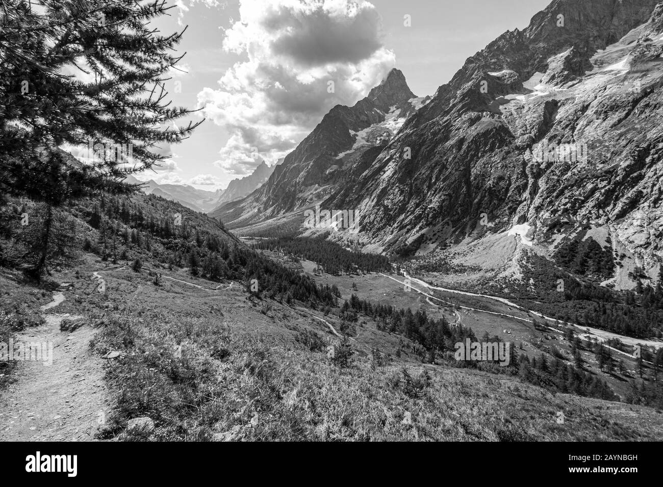 Le sentier de randonnée Tour du Mont Blanc à travers les Alpes italiennes avec un glacier sur une montagne dans la vallée en arrière-plan Banque D'Images