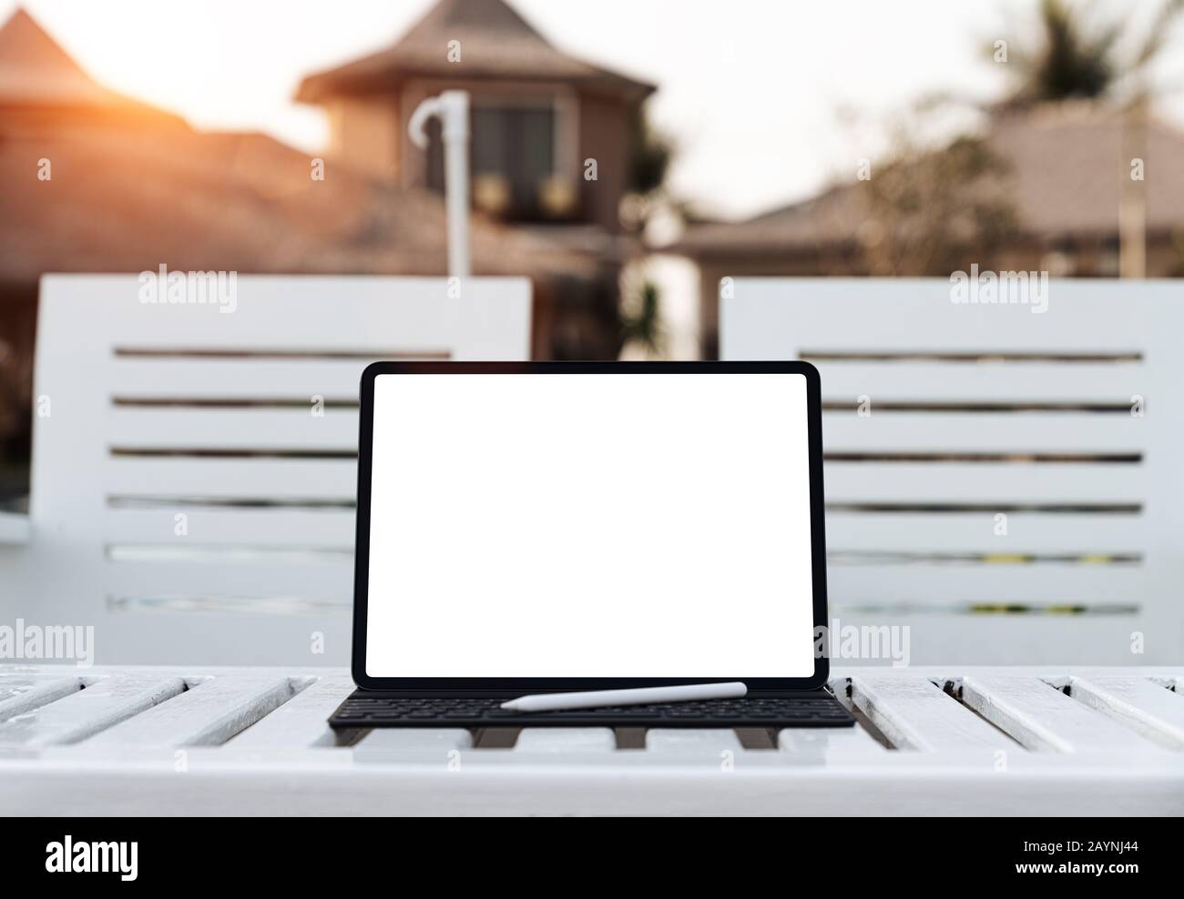 tablette numérique écran blanc sur la table au coucher du soleil Banque D'Images