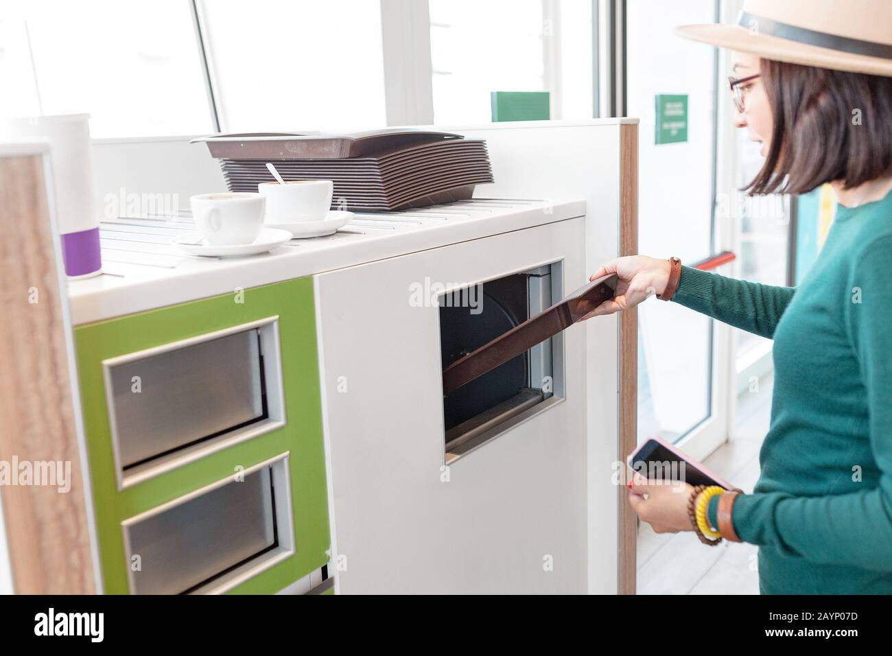 Femme mettant les ordures et les restes du restaurant fastfood à la poubelle de recyclage Banque D'Images