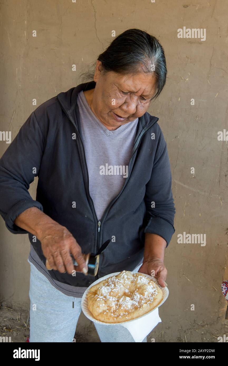 Une femme américaine indigène fait du pain de friture indienne devant sa maison au Taos Pueblo qui est la seule communauté autochtone vivante designa Banque D'Images