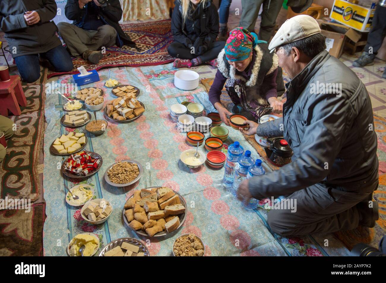 Le déjeuner se répand avec une femme kazakh préparant le traditionnel suutei tsai (thé au lait) dans la cuisine du camp d'hiver (maison) dans la vallée de Sagsai dans TH Banque D'Images