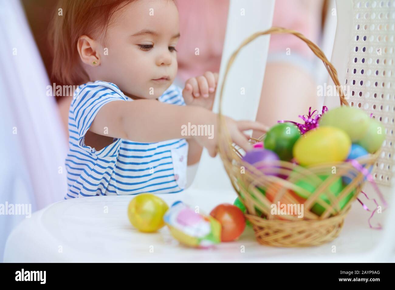 Petite fille mignonne avec panier d'œufs de pâques sur l'arrière-cour de la maison Banque D'Images