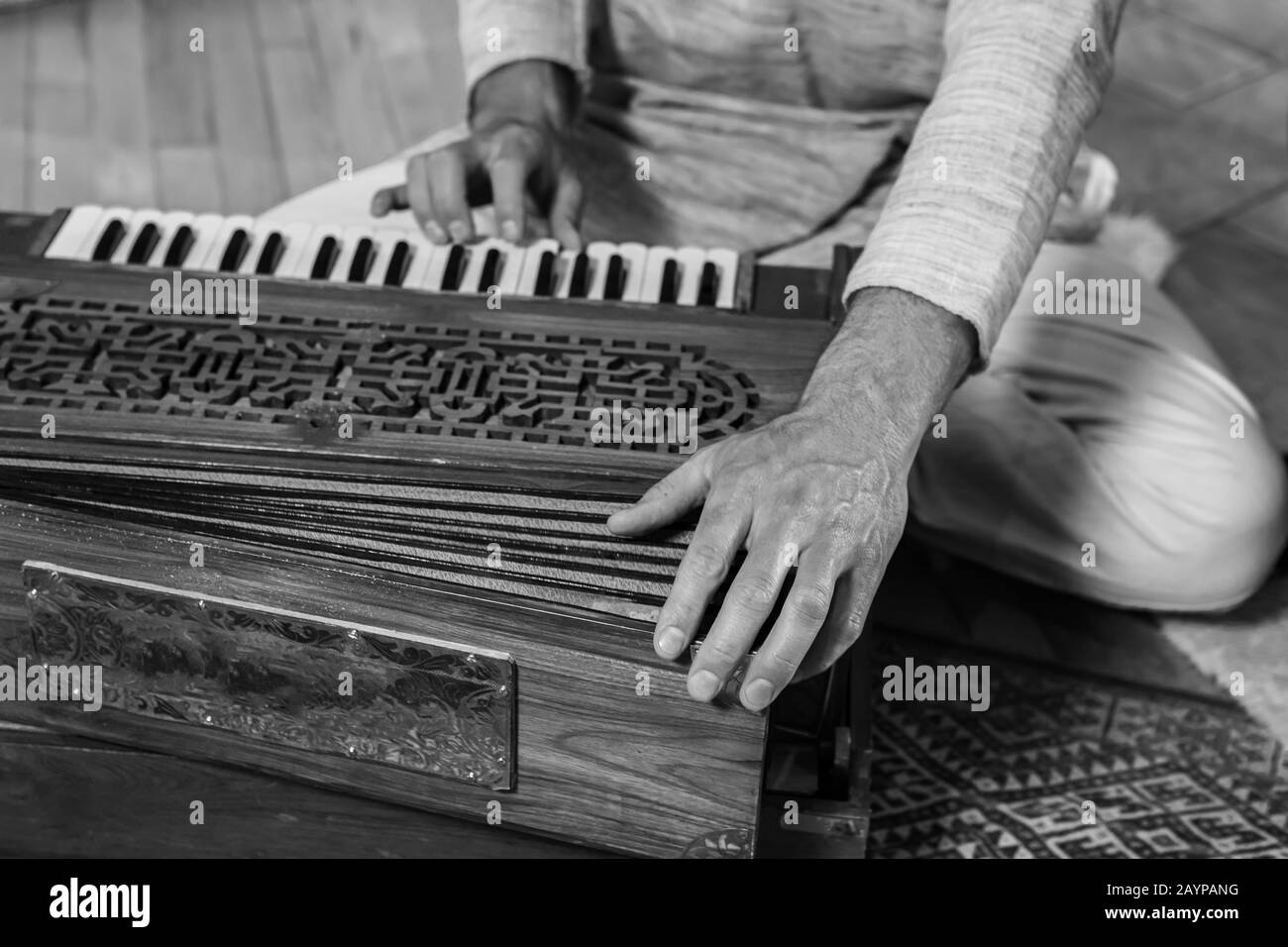 Gros plan sur les mains chamaniques de sexe masculin jouant l'harmonium de l'instrument de musique indien comme musique sacrée et kirtan pour une méditation pacifique Banque D'Images