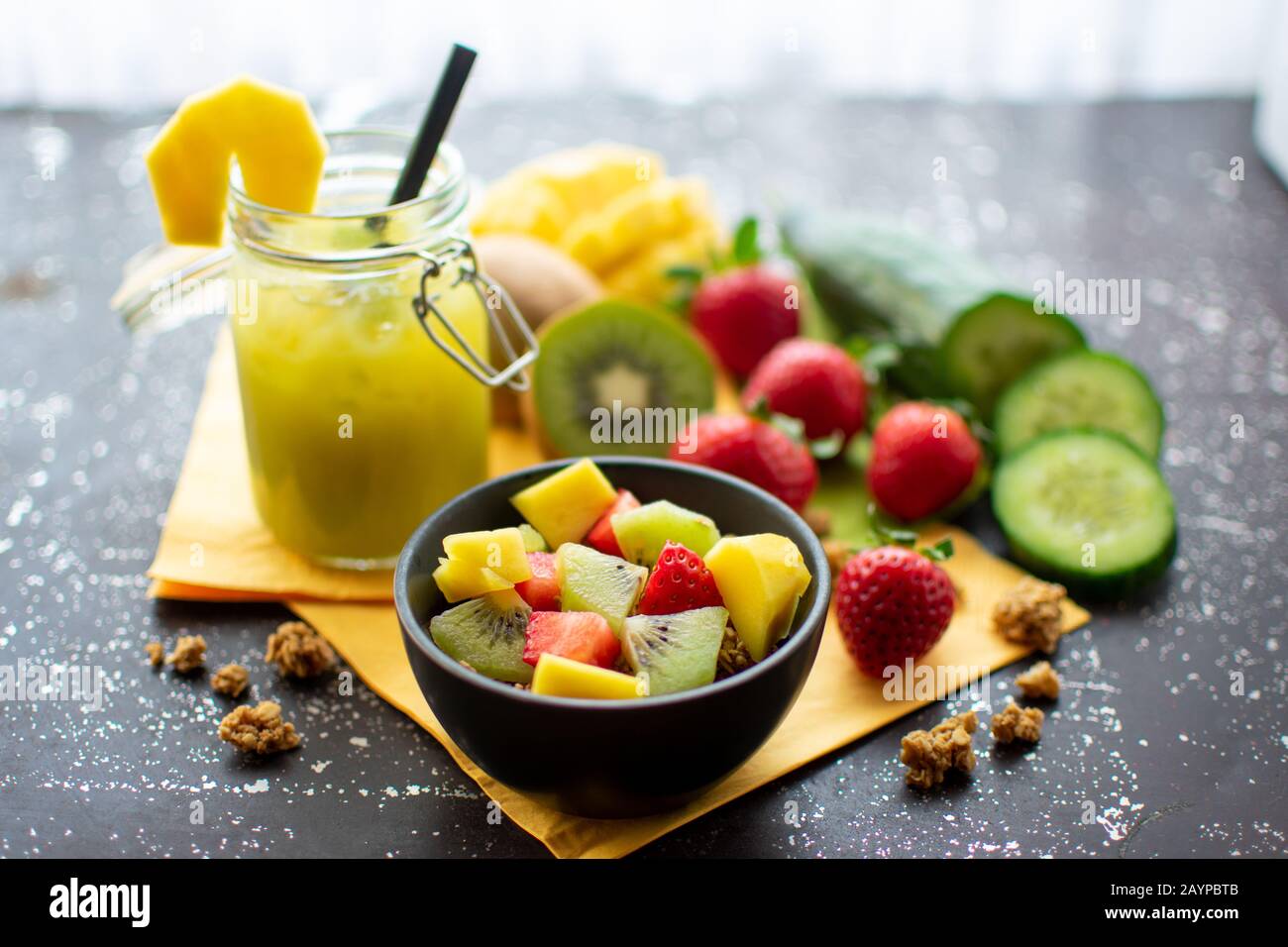 petit déjeuner sain : muesli croustillant avec fraises fraîches, kiwi et mangue avec délicieux smoothie vert dans un pot Banque D'Images