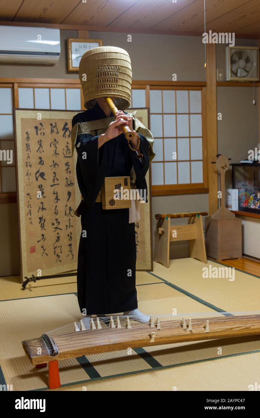 Un homme japonais dans des moines traditionnels se déguisait à Kyoto, au Japon, joue un shakuhachi japonais traditionnel, une flûte japonaise à la fin. Banque D'Images