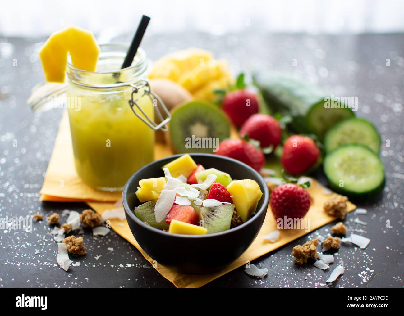 petit déjeuner sain : muesli croustillant avec fraises fraîches, kiwi, mangue et flocons de noix de coco avec délicieux smoothie vert dans un pot Banque D'Images