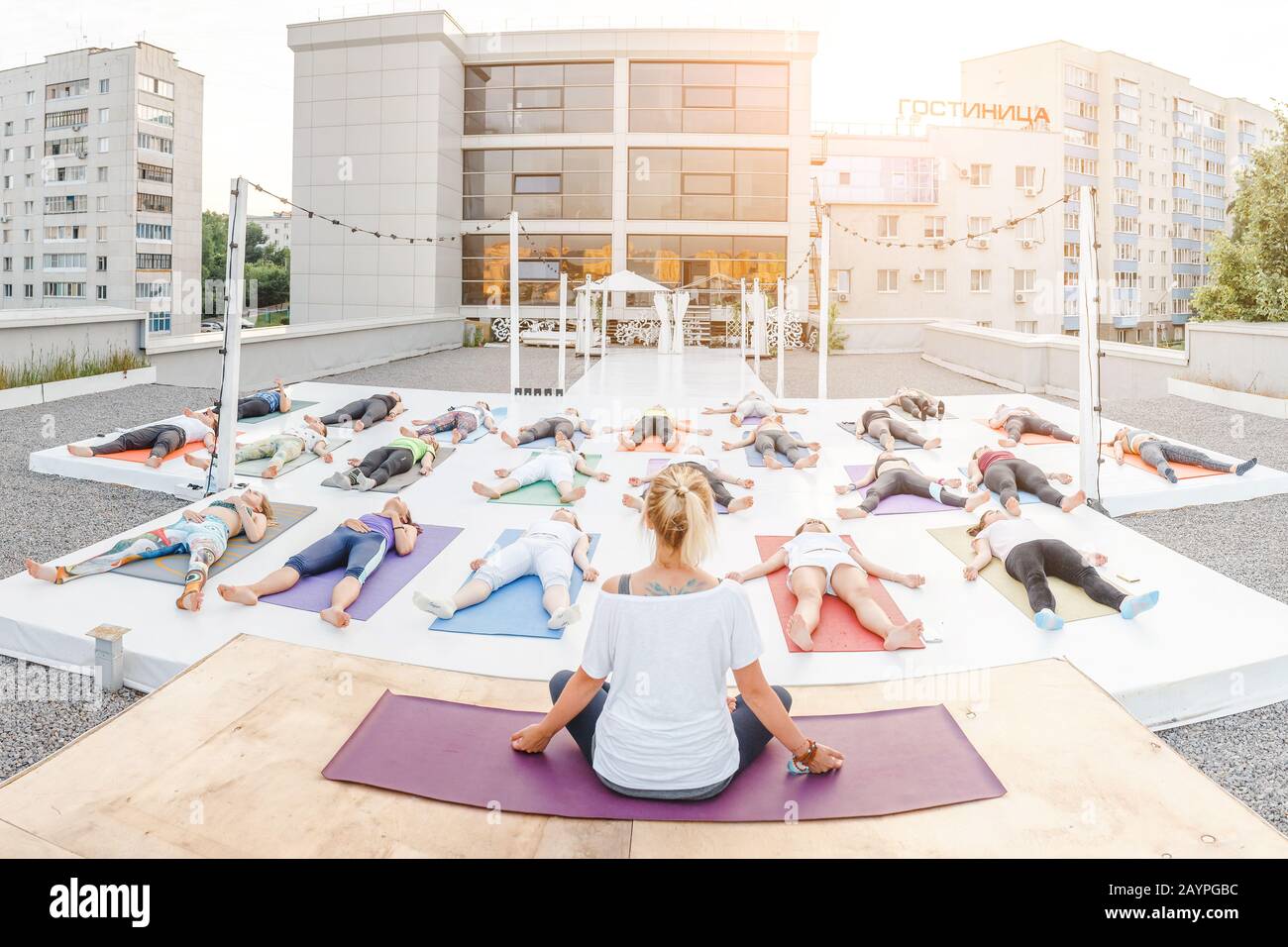 01 JUILLET 2018, UFA, RUSSIE: Un groupe de personnes dans poses asana faire des exercices de yoga sur le toit Banque D'Images