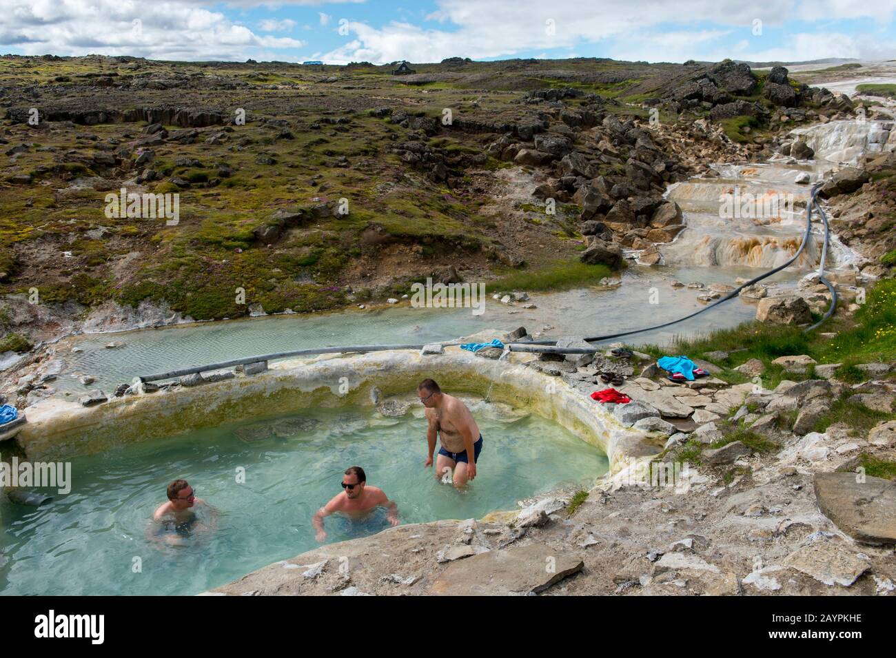 Les gens se baignent dans une piscine alimentée par des sources chaudes à Hveravellir, une zone géothermique de fumarales, et des piscines chaudes multicolores dans les hautes terres centrales de Banque D'Images