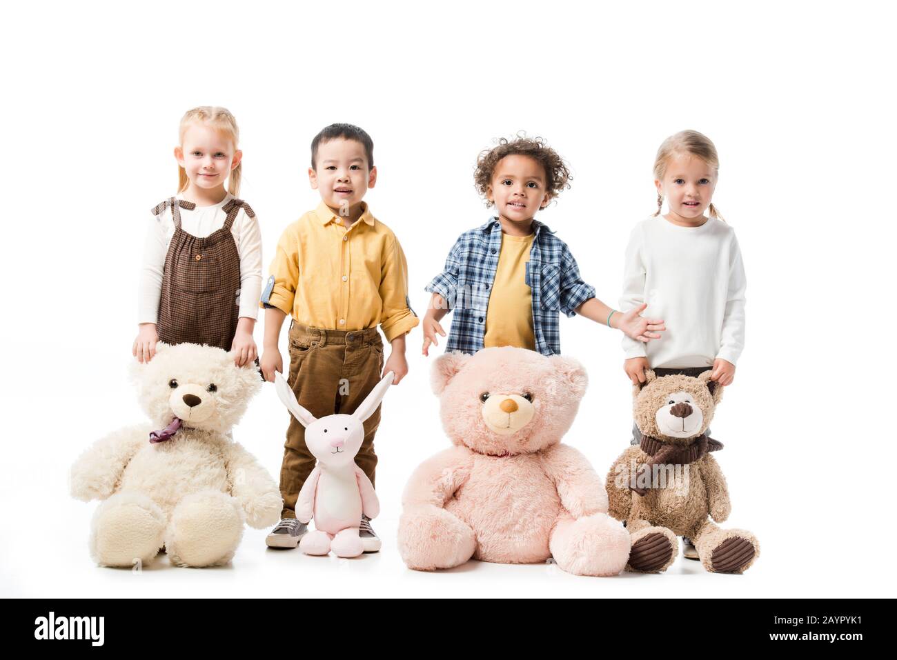 joyeux enfant multiculturel debout avec des ours en peluche et un jouet lapin Banque D'Images