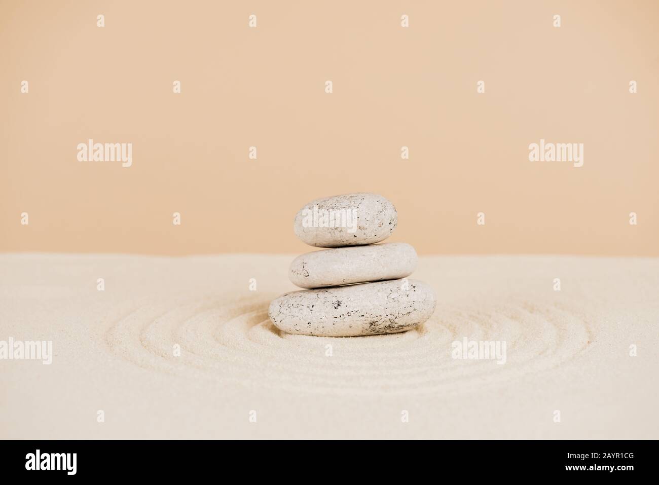 Pierres zen sur sable avec cercles sur fond beige Banque D'Images