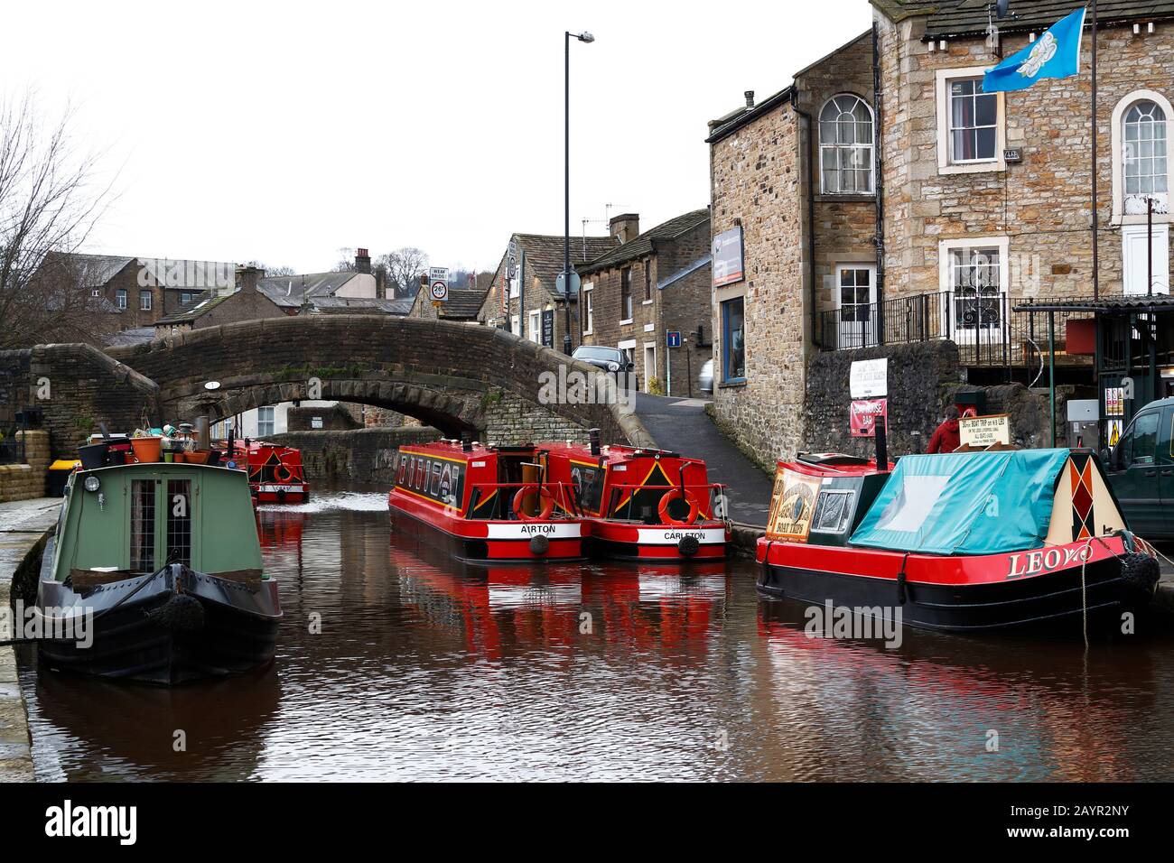 Des bateaux étroits colorés amarrés à Skipton sur le canal de Leeds à Liverpool pendant les mois d'hiver avec ciel gris au-dessus de la plupart des bateaux sur la photo sont à louer pendant la saison touristique. Banque D'Images