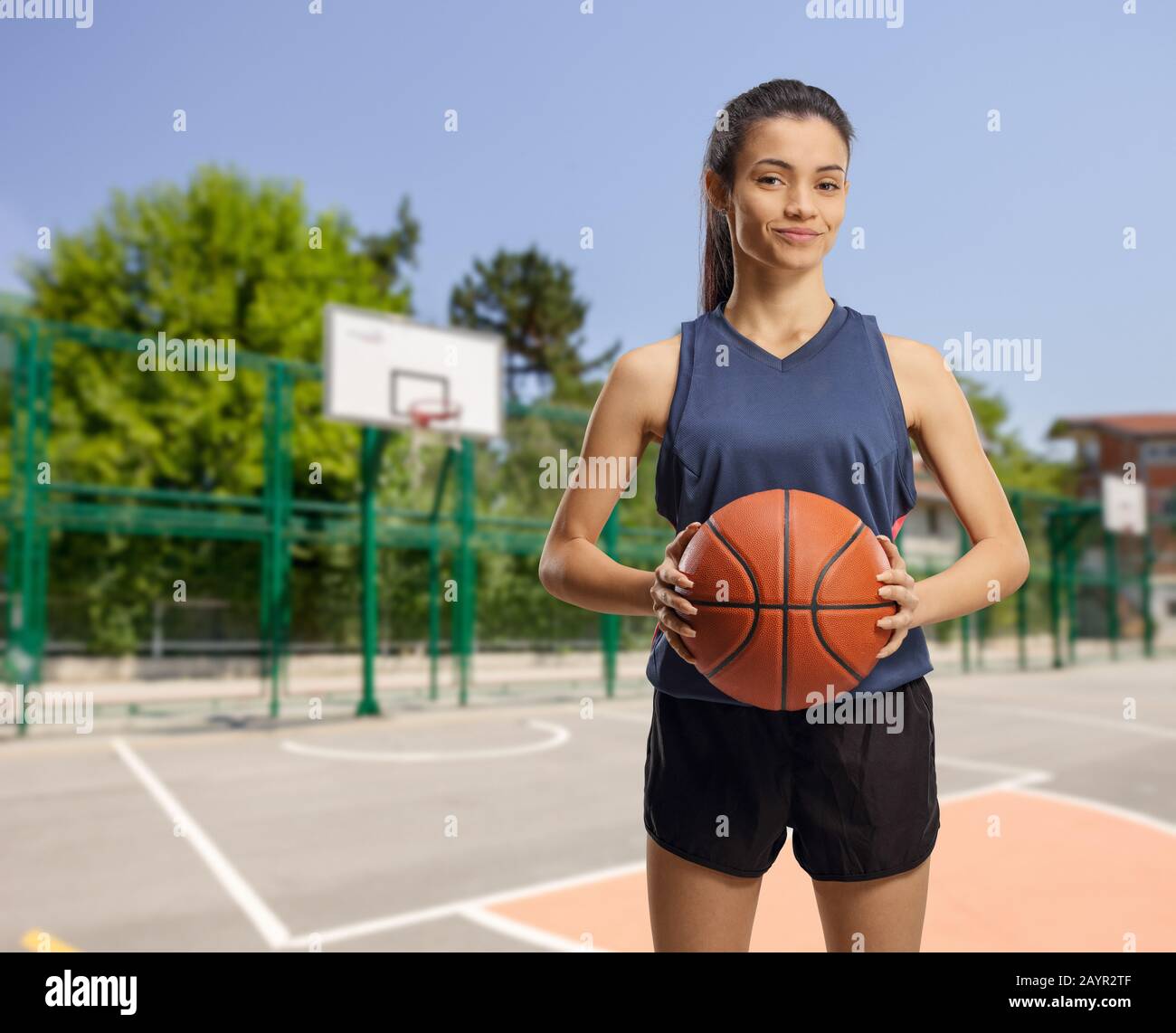 Jeune femme avec un terrain de basket-ball extérieur isolé sur fond blanc Banque D'Images