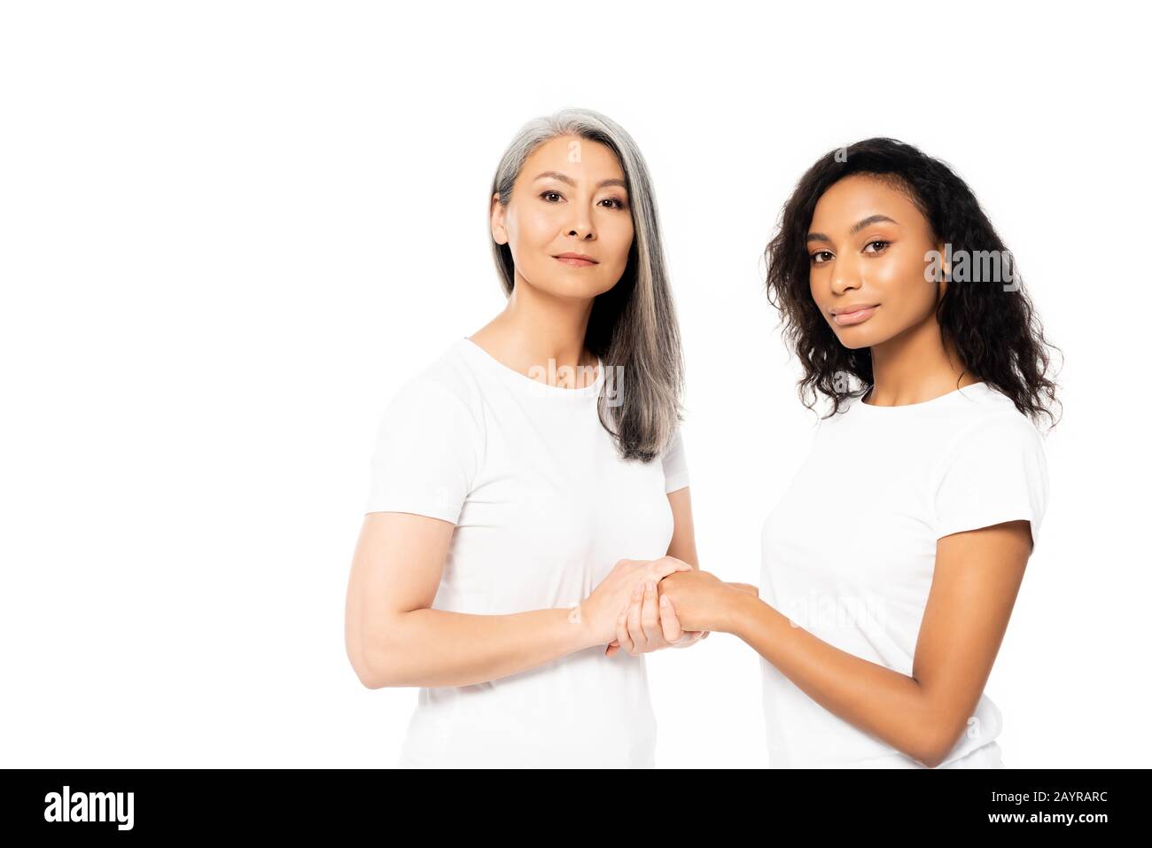 des femmes africaines attrayantes, américaines et asiatiques, se tenant les mains isolées sur le blanc Banque D'Images