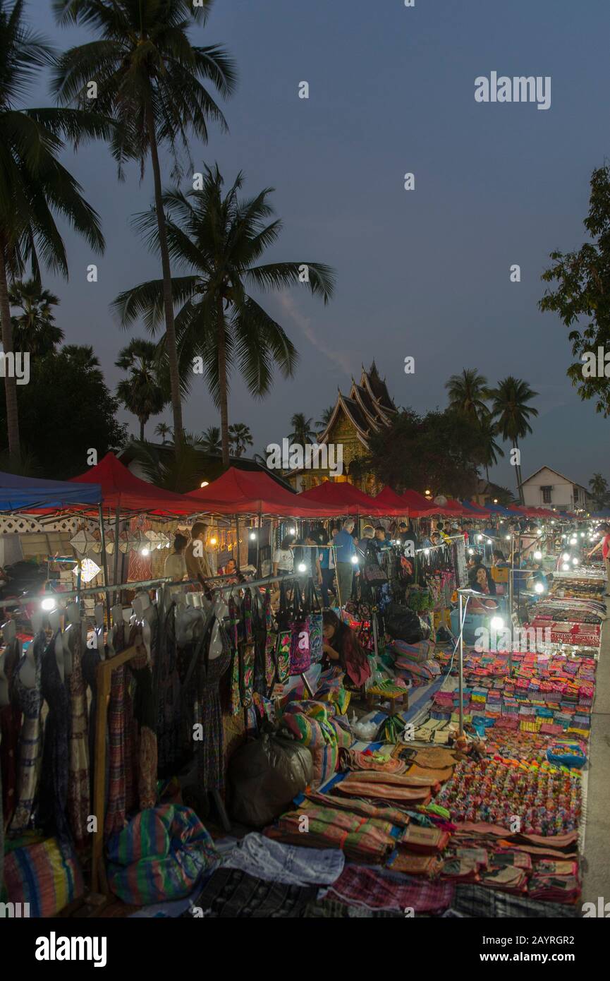 Vue sur le marché quotidien de nuit dans la ville de Luang Prabang, classée au patrimoine mondial de l'UNESCO au Laos central, avec le Haw Pha Bang (le temple royal) de la Roya Banque D'Images