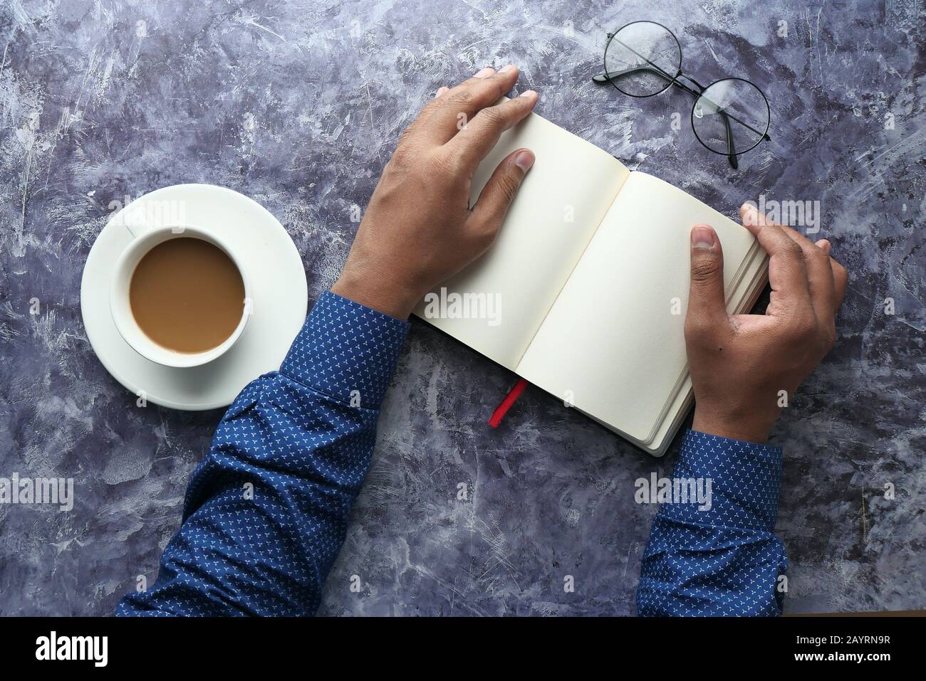 vue de dessus de la main de l'homme sur le journal et le thé sur la table Banque D'Images