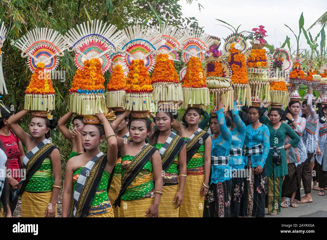 Bali, Indonésie - 26 juillet 2010: Groupe de femmes en costumes traditionnels et offre colorée sur leur tête marcher jusqu'au temple Saint Pura Tanah Lot. Banque D'Images