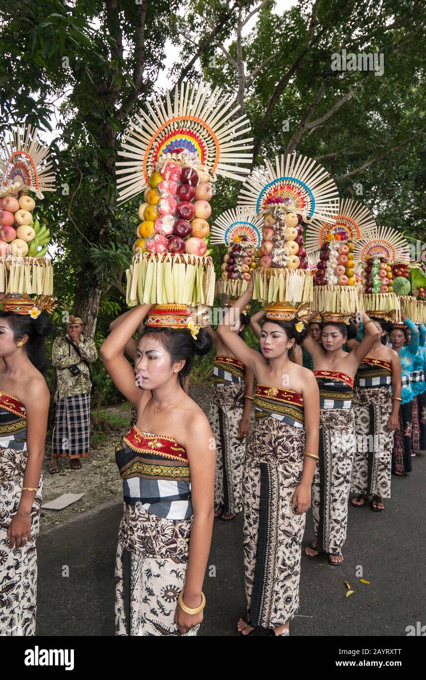 Bali, Indonésie - 26 juillet 2010: Groupe de femmes en costumes traditionnels et offre colorée sur leur tête marcher jusqu'au temple Saint Pura Tanah Lot. Banque D'Images