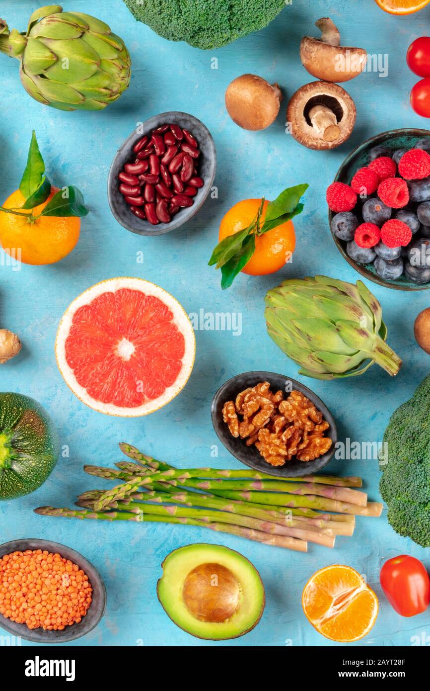 Repas végétaliens, plan plat de plan de régime sain. Fruits, légumes, légumineuses, champignons, noix, tiré du dessus sur un fond bleu Banque D'Images