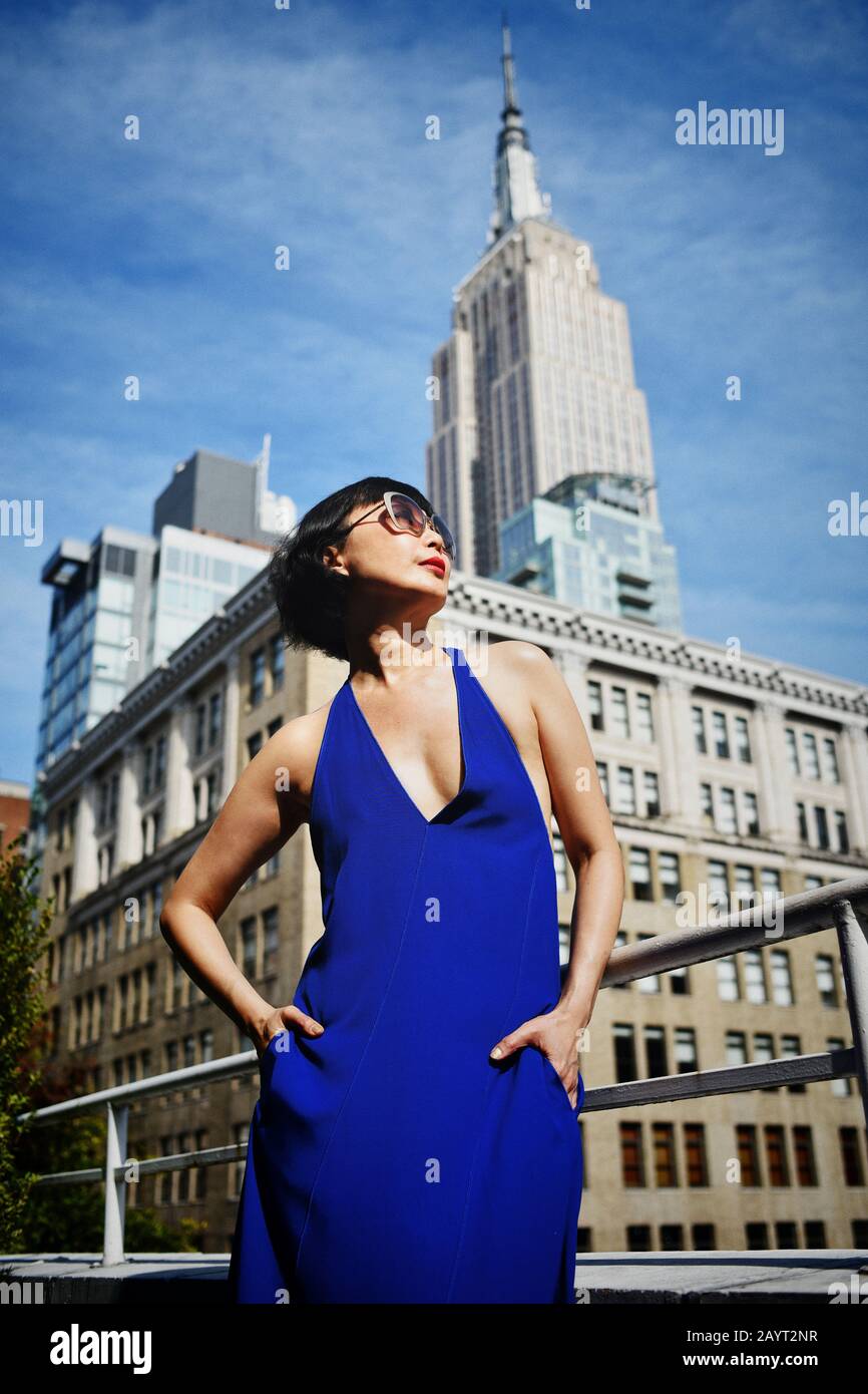 Lifestyle Fashion Shoot - une femme asiatique élégante sur la terrasse surplombant le sommet de l'Empire State Building à Midtown Manhattan, New York Banque D'Images