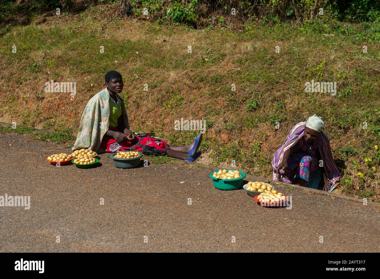 Les femmes qui vendent des pommes de terre le long d'une route sur le plateau de Zomba au Malawi. Banque D'Images