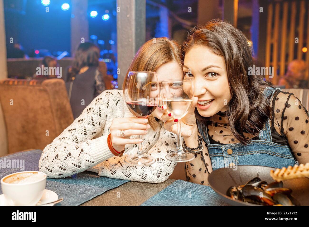 Deux filles amis s'amusent et bavarder tout en buvant un verre de vin dans un restaurant dans une discothèque. Le concept de détente et de frégate Banque D'Images