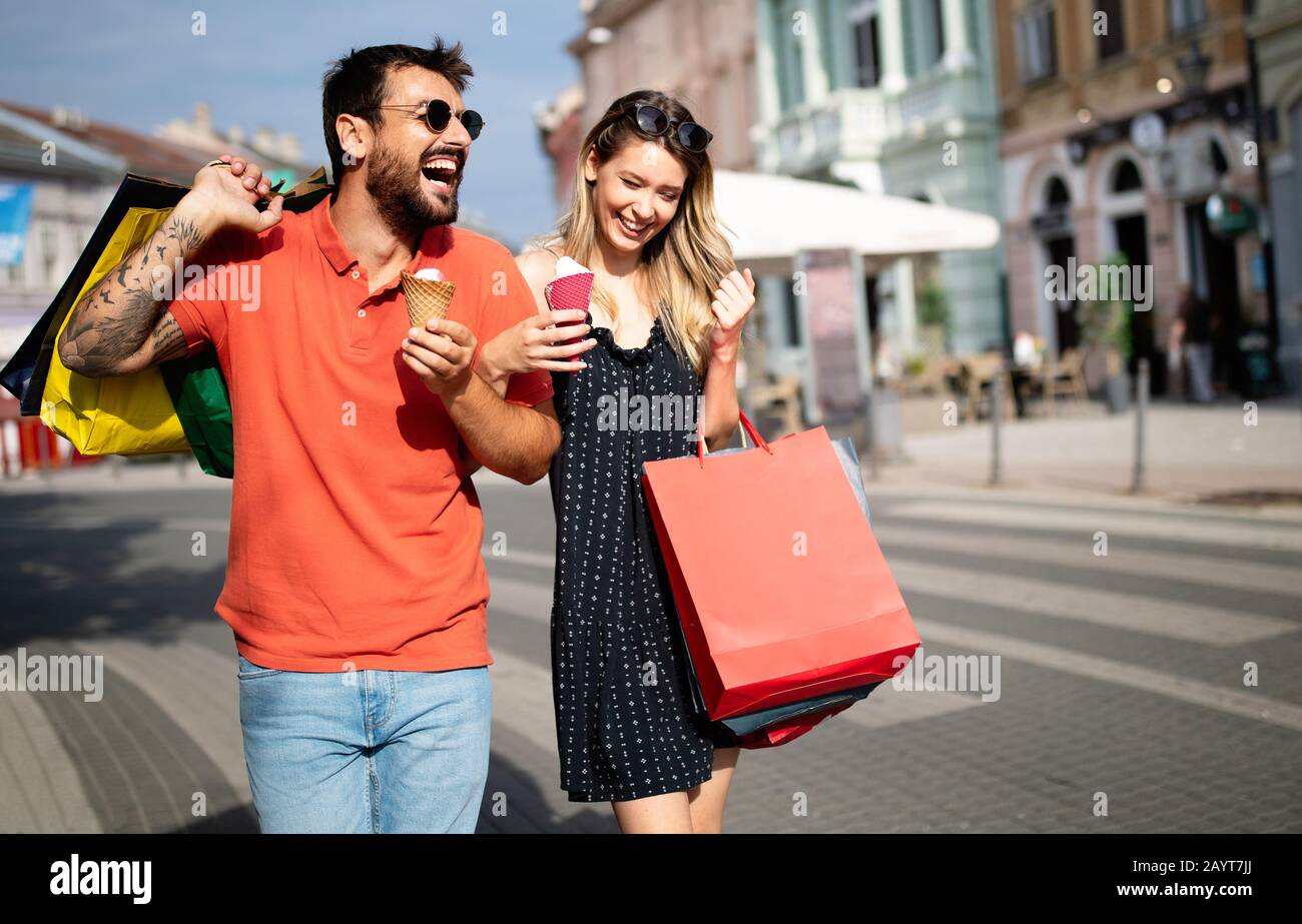 Vente, consumérisme et concept de personnes. Couple heureux avec des sacs de shopping dans la ville Banque D'Images