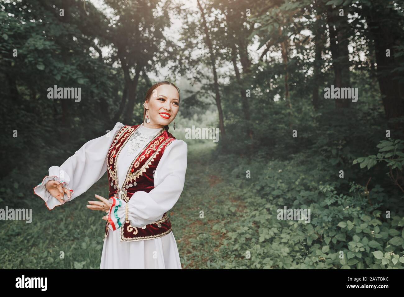 Une femme en vêtements traditionnels turkiques orientaux brodés exécute une  danse nationale dans le parc Photo Stock - Alamy