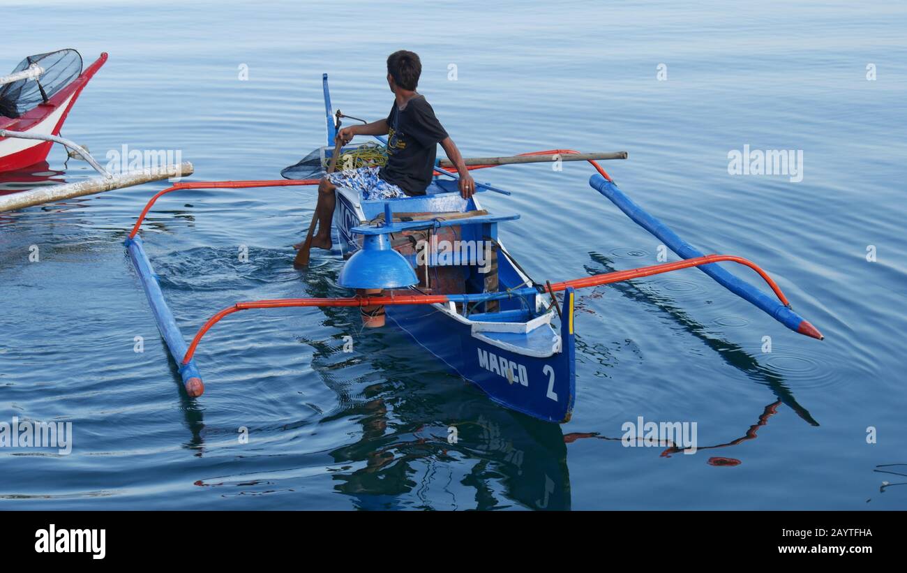 Banay Banay Banay, Davao Oriental, Philippines - Mars 2016 : un pêcheur part dans un bateau outrigger bleu au village de pêche de Punta Linao dans le sud de la P Banque D'Images