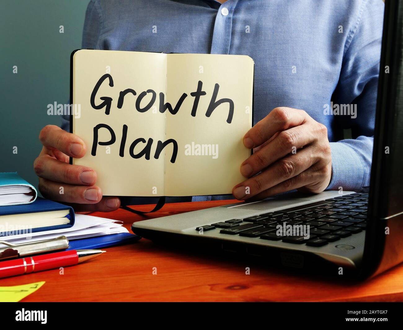 L'homme qui tient un plan de croissance et est assis à la table. Banque D'Images