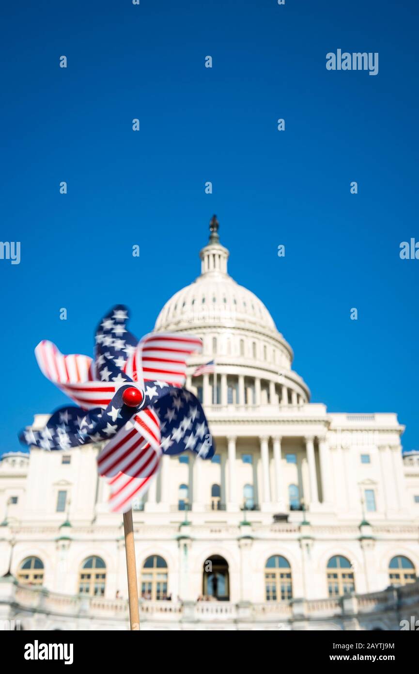 Flou de mouvement vue de la roue à broche du drapeau américain qui tourne dans le ciel bleu ensoleillé devant le Capitole américain à Washington DC, États-Unis Banque D'Images
