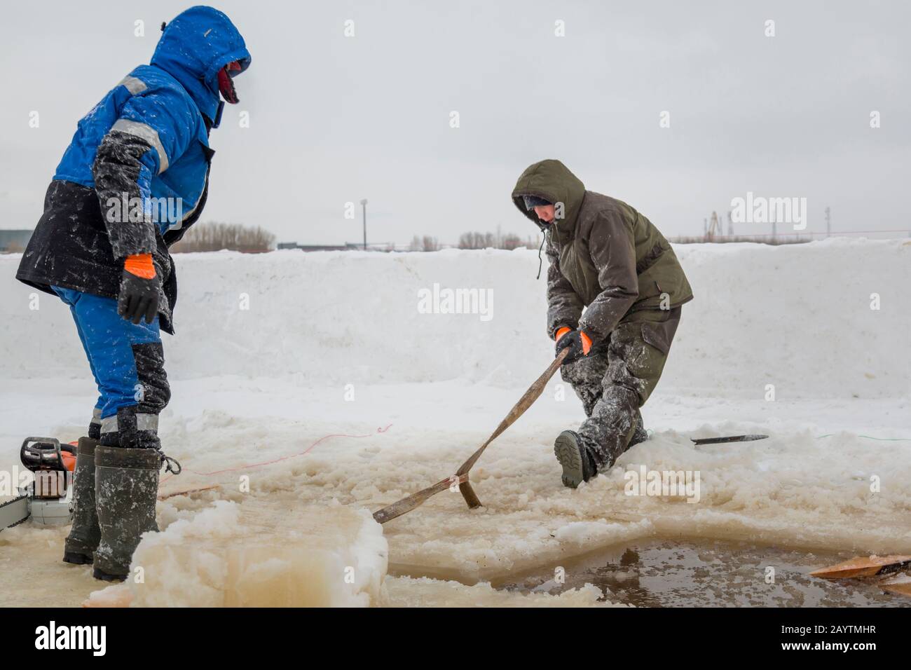 Porter des vêtements de travail de protection avec une capuche sur la tête, des élingues sous le bloc de glace Banque D'Images