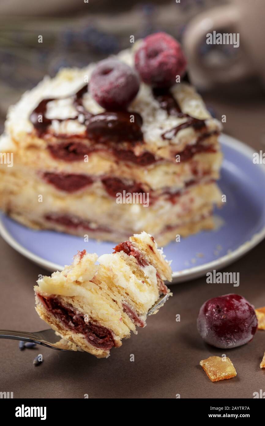 Un délicieux gâteau de cerise d'été sur une plaque de couleur lavande avec tasse de thé, gros plan Banque D'Images