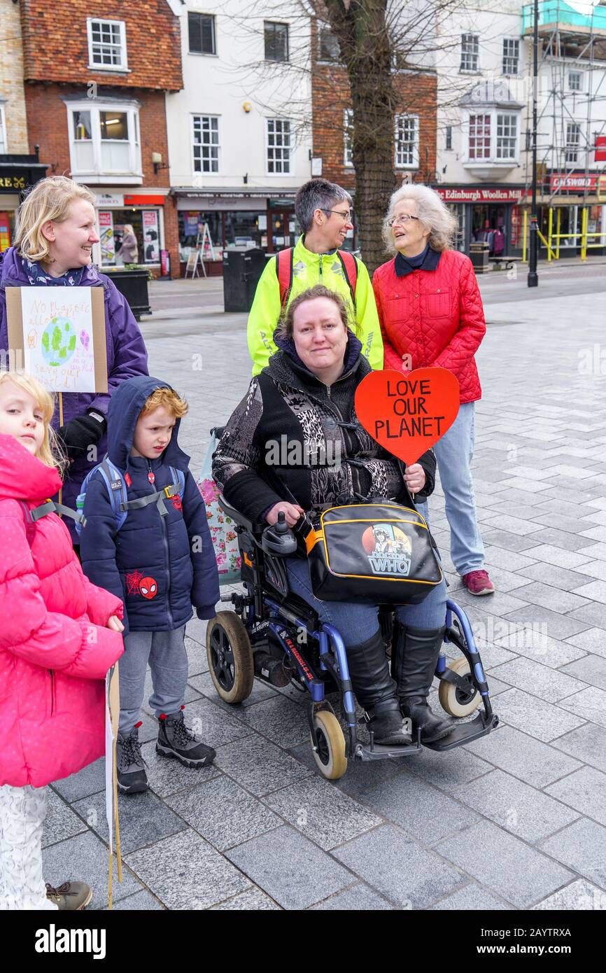 Dame en fauteuil roulant tenant un signe rouge en forme de coeur disant aimer notre planète lors d'une manifestation sur le changement climatique Banque D'Images