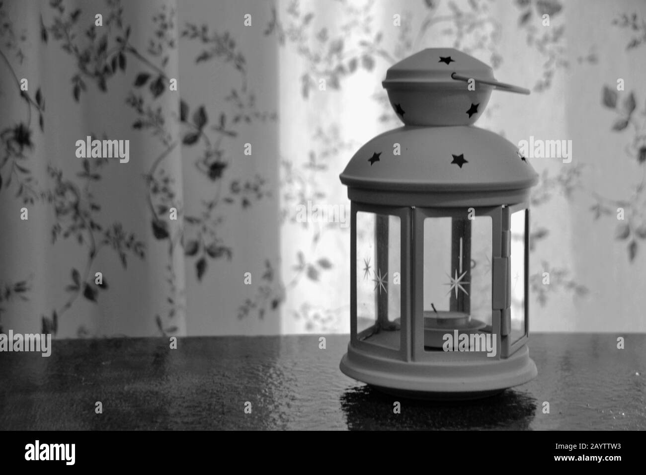 Lanterne noire et blanche avec porte-bougie décoratif avec fond fleuri Banque D'Images