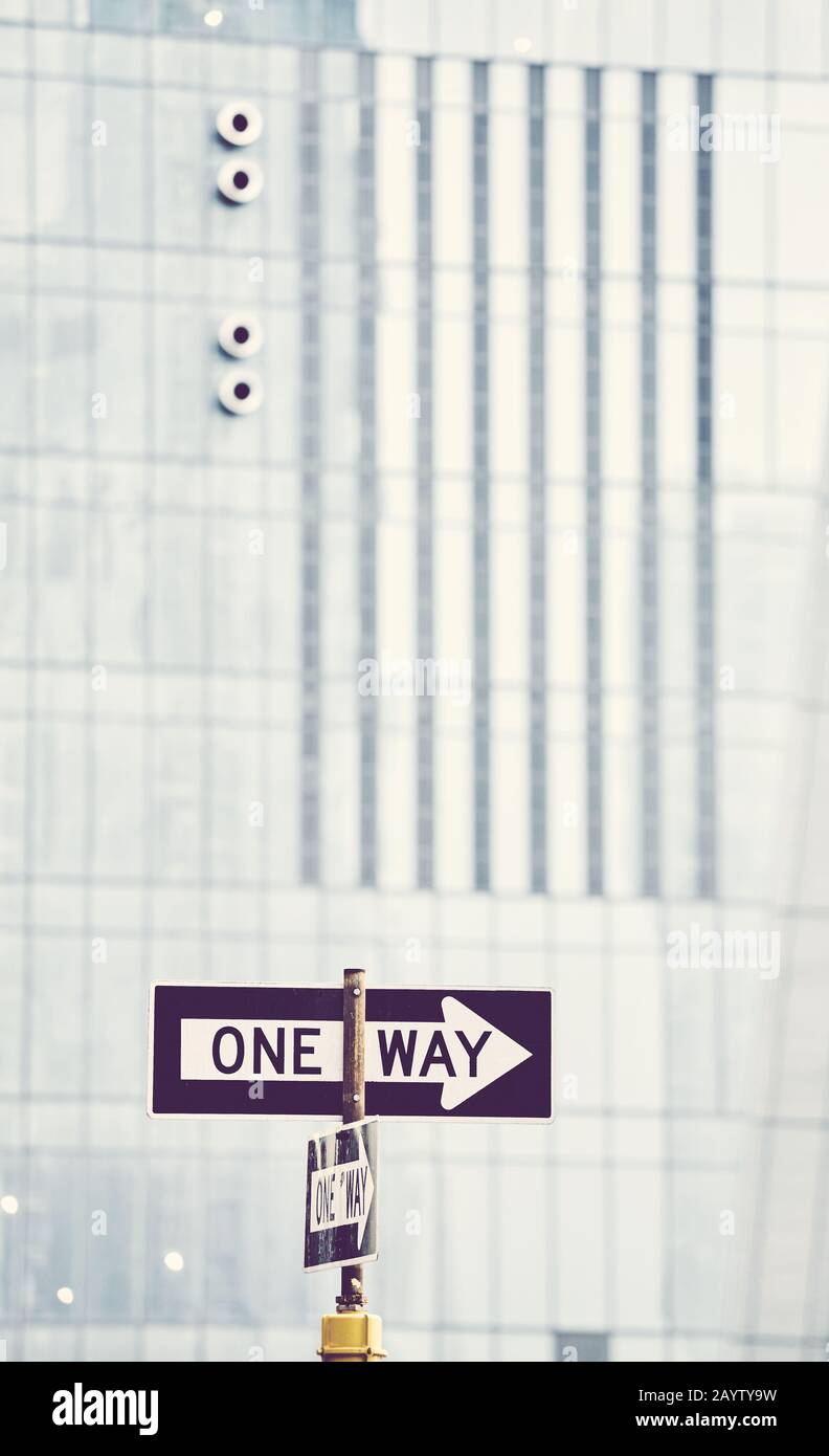 Panneau de signalisation unidirectionnel avec bâtiment moderne en arrière-plan, mise au point sélective, couleur appliquée, New York City, États-Unis. Banque D'Images