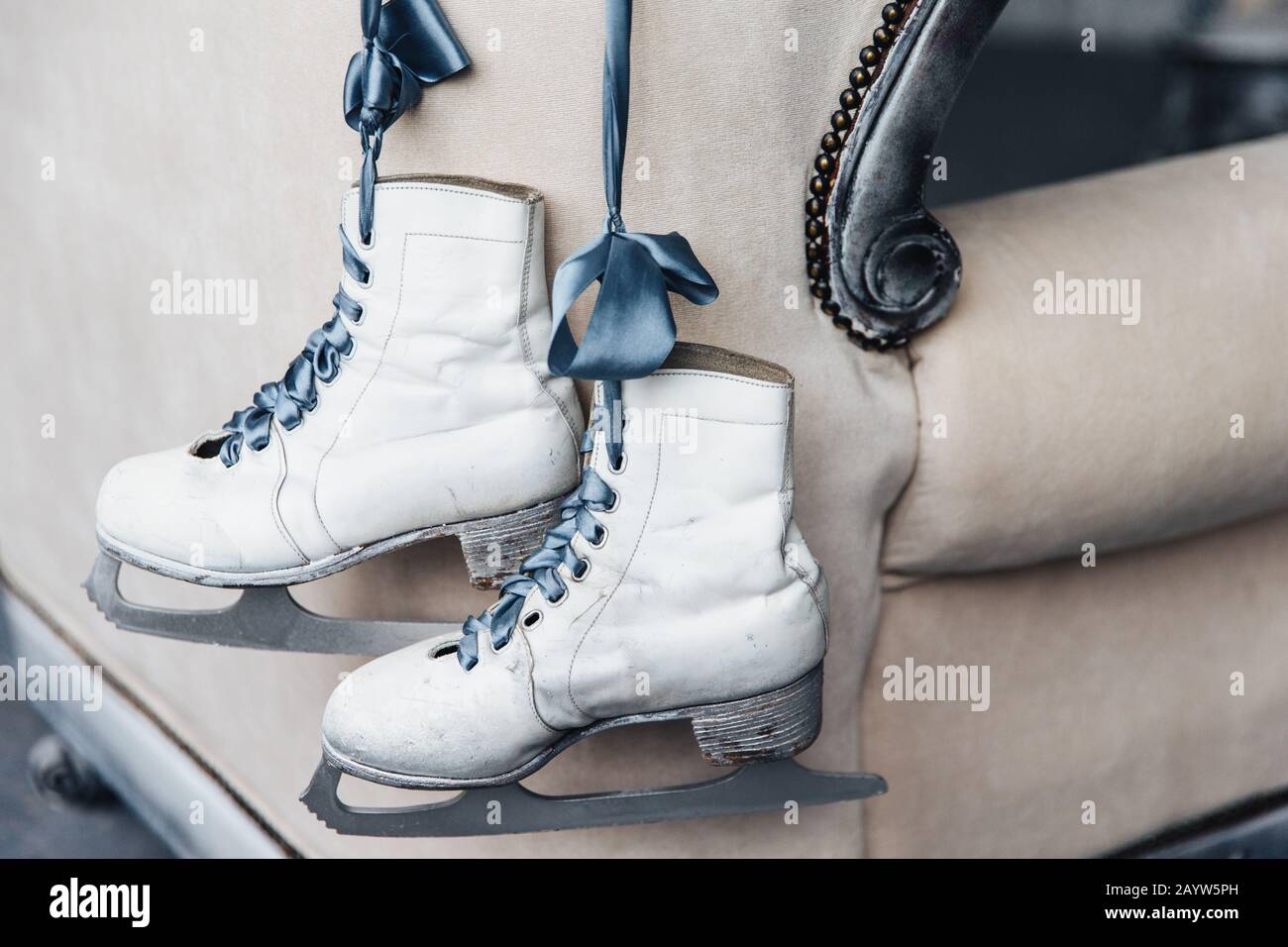 Photo de la paire de patins blancs en cuir d'hiver portés pour le patinage artistique avec des lacets accrochés sur le ruban. A utilisé des patins de femmes de skater professionnel ou de glace hoc Banque D'Images