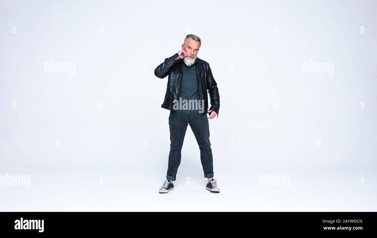 Homme senior avec barbe dans des vêtements à la mode . Homme senior en veste debout sur fond blanc. Banque D'Images